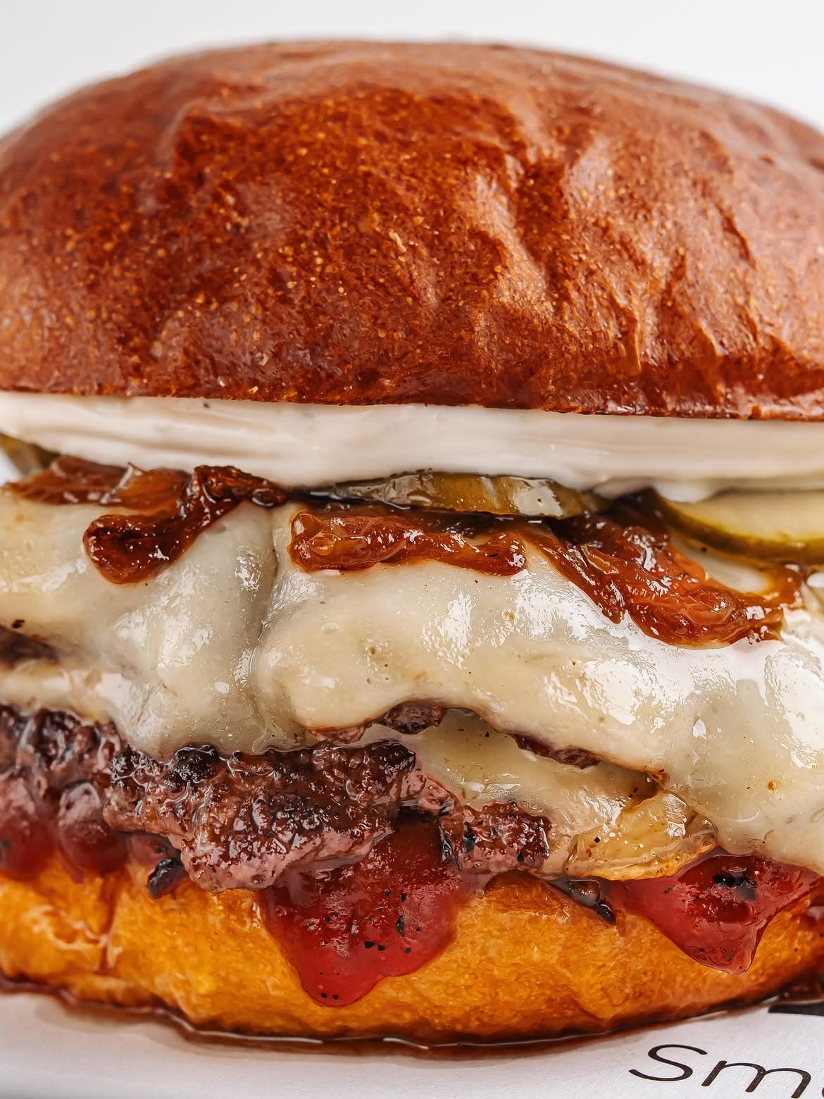 Əridilmiş pendir və qızarmış kənarları görünən Fero smash burger