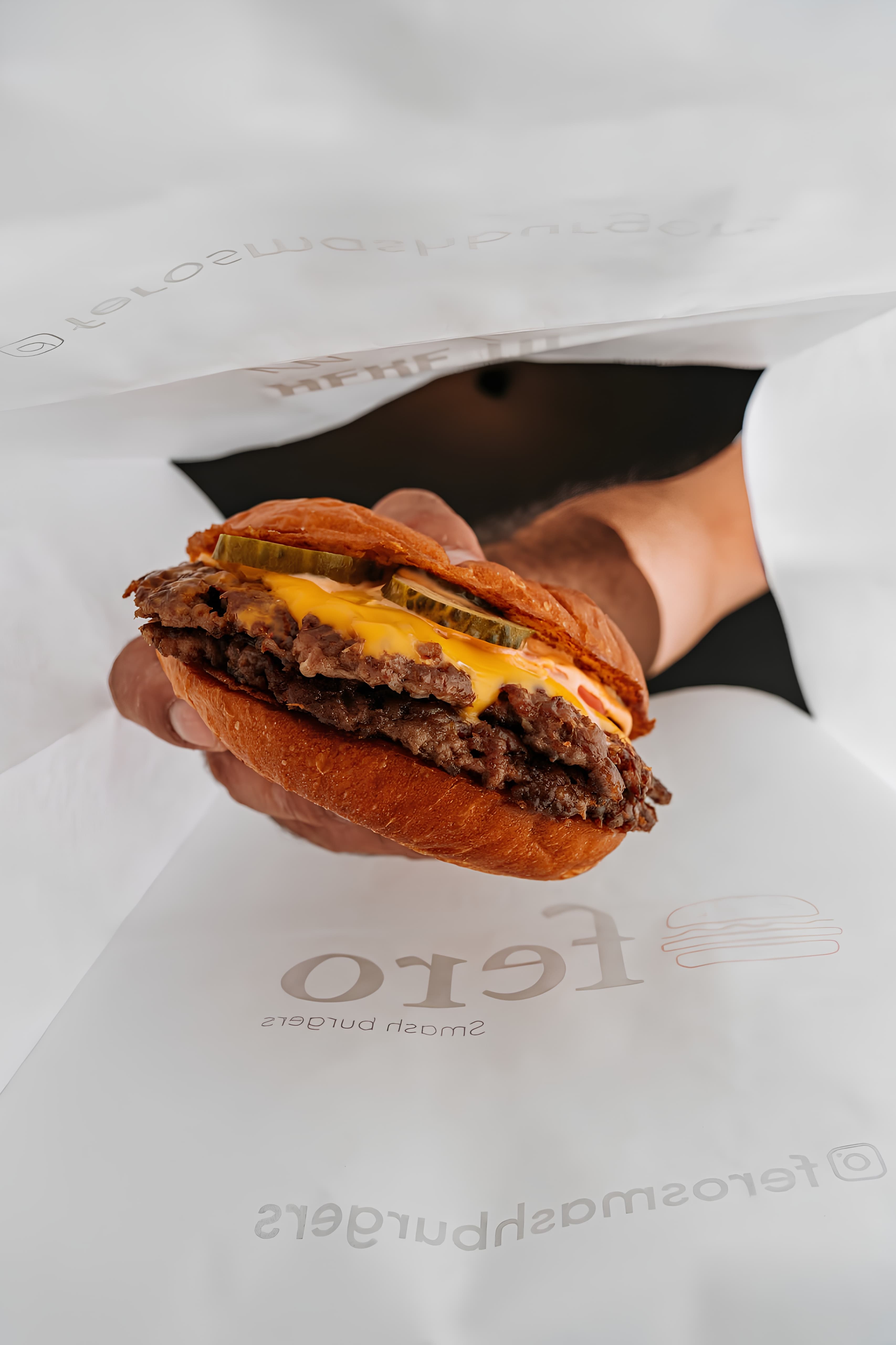 Əridilmiş pendirin üzərində sous axan Fero smash burger